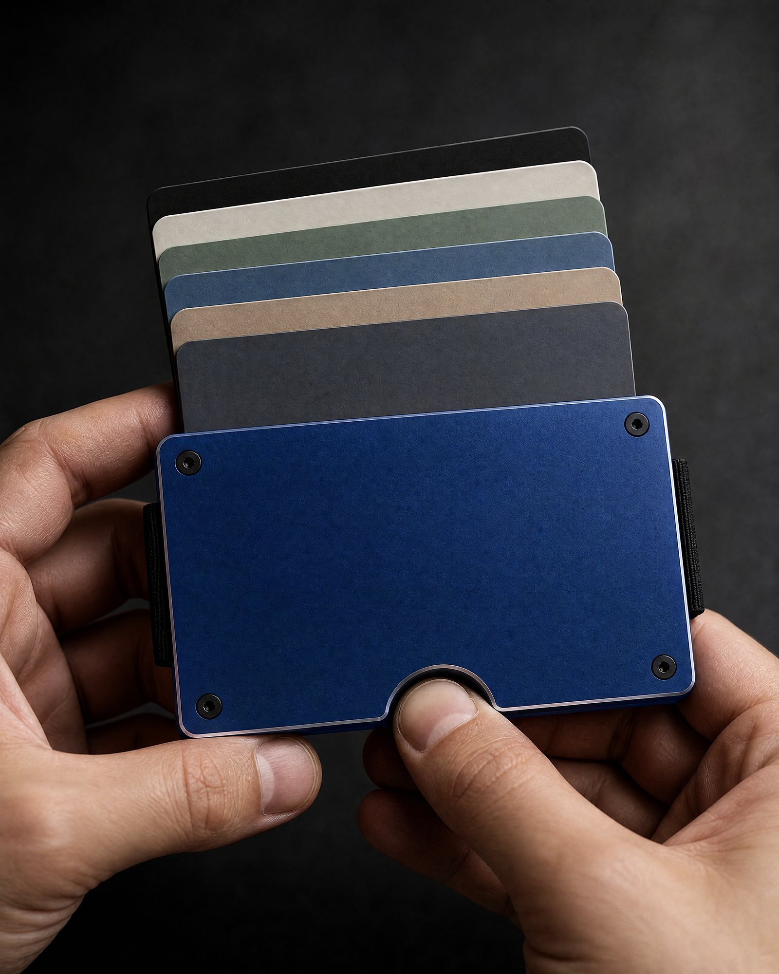 A thumb pushing cards out of an ANODE wallet, the cards fanned out